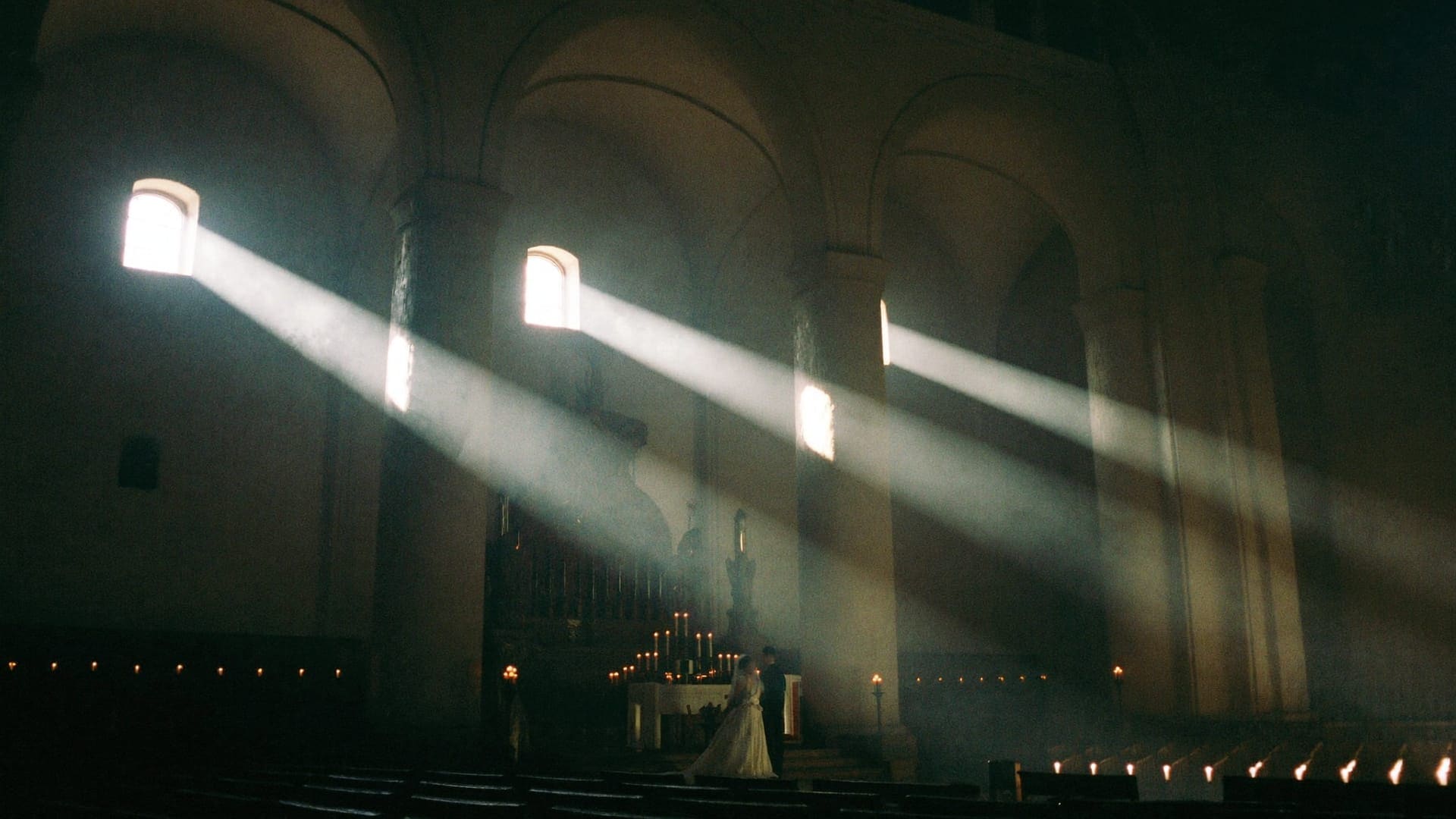 Lumina coborând prin ferestrele înalte ale bisericii, mirii la altar